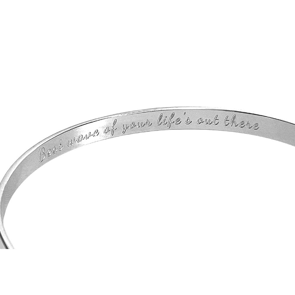 Silver cuff bracelet showing inner engraved motto along the band