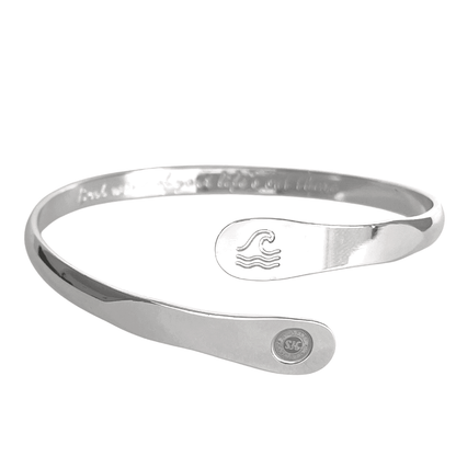 Silver wave-engraved cuff bracelet with oval wave emblem and round logo side disc.