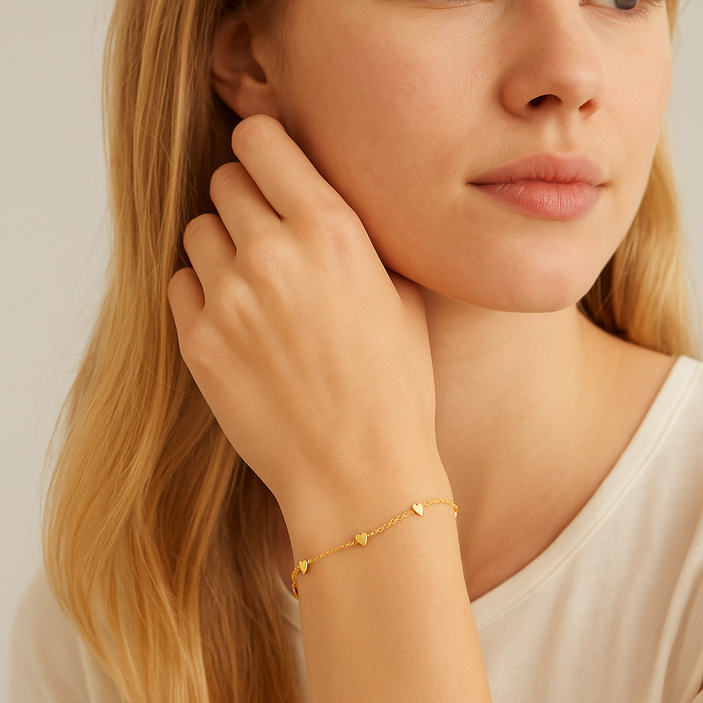 Gold heart charm bracelet with tiny heart dangles worn on wrist