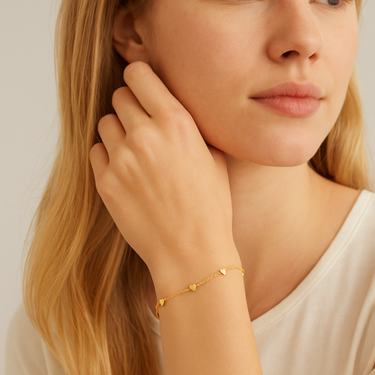 Gold heart charm bracelet with tiny heart dangles worn on wrist