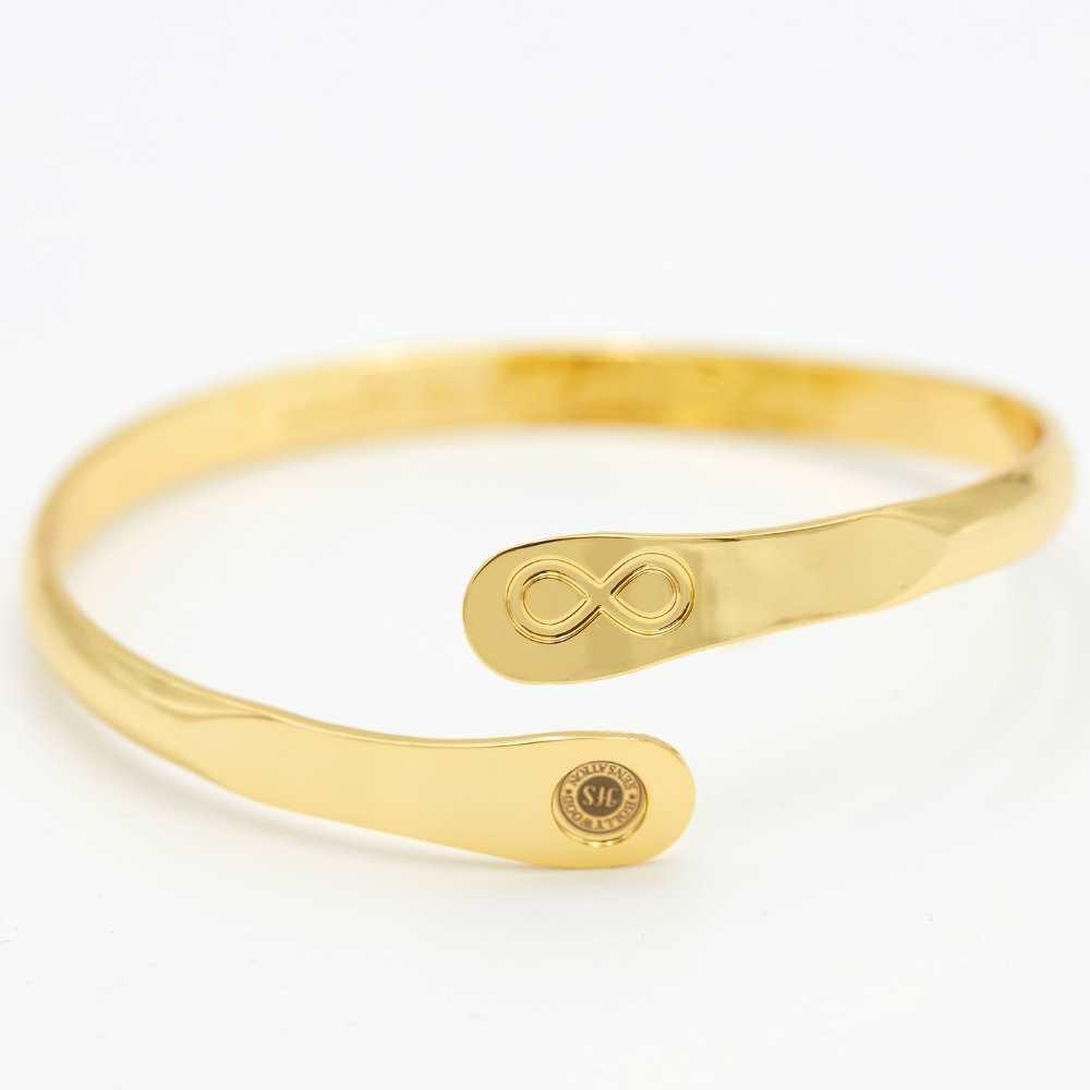Gold infinity friendship bracelet with infinity charm and round brand stamp on end