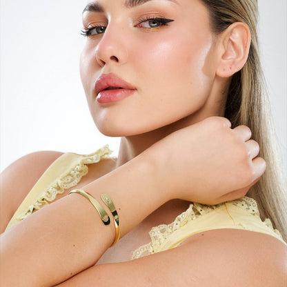 Gold pet paw-print bracelet on wrist, engraved paw center on slim cuff