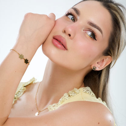 Gold double paw print pendant necklace on model’s neckline, small charm pendant.
