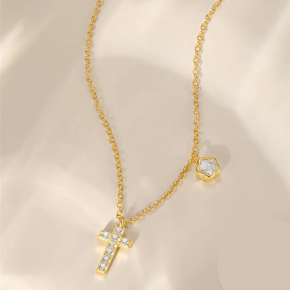 Gold-tone cross pendant necklace with sparkling CZ and small floral charm