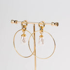 Gold-tone drop hoop earrings with simulated pearl teardrop charms, front view
