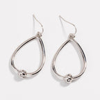 Silver teardrop hoop earrings with love-knot charm at the bottom