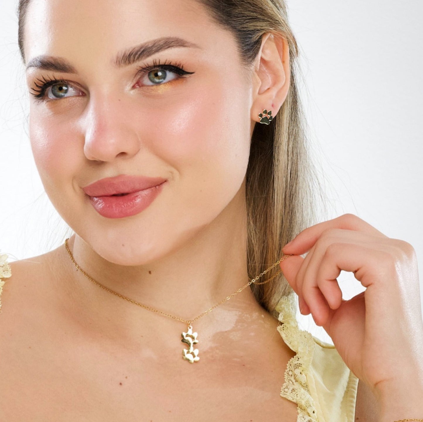 Gold-tone double paw print pendant necklace worn on model