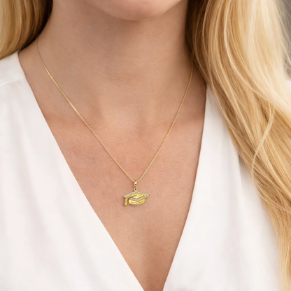 Gold graduation cap pendant necklace worn on the neck with “Limitless” engraving