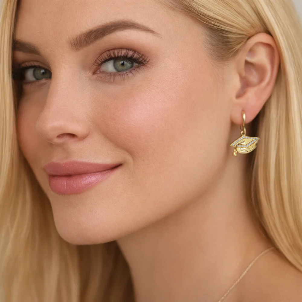 Gold huggie hoop earrings with graduation cap charm labeled “Limitless”