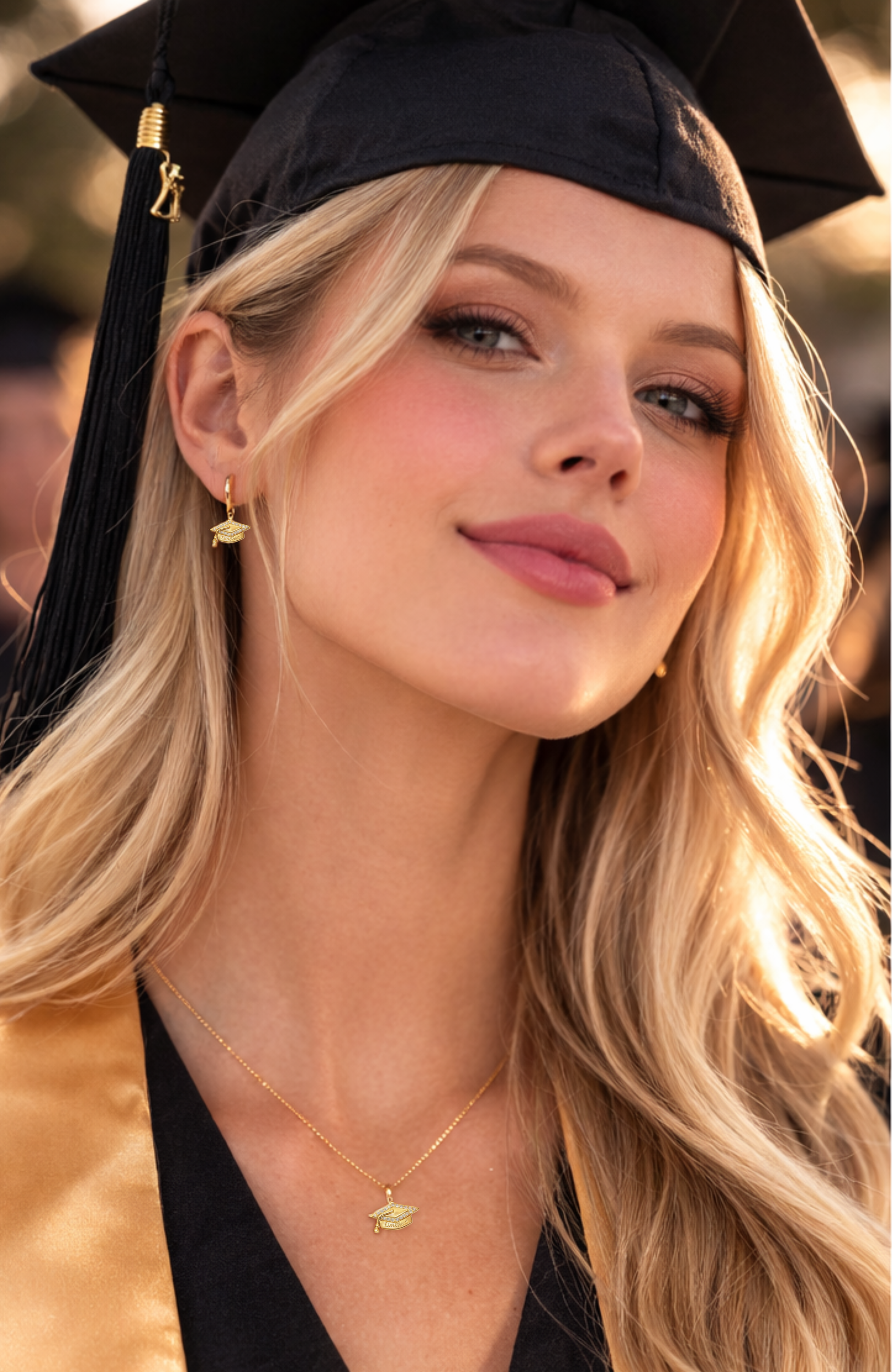Gold graduation cap charm earrings with “Limitless” text, shown on a huggie hoop style
