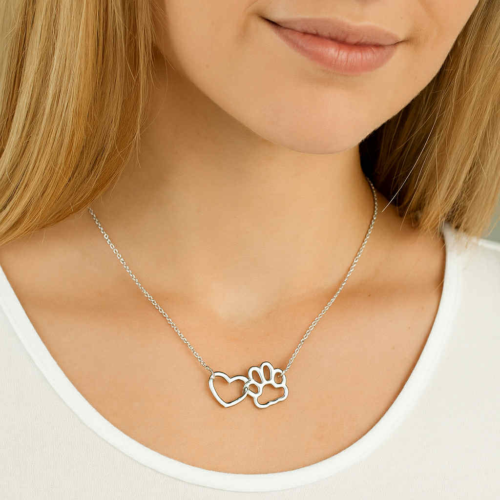 Silver heart and paw pendant necklace on thin chain, close-up