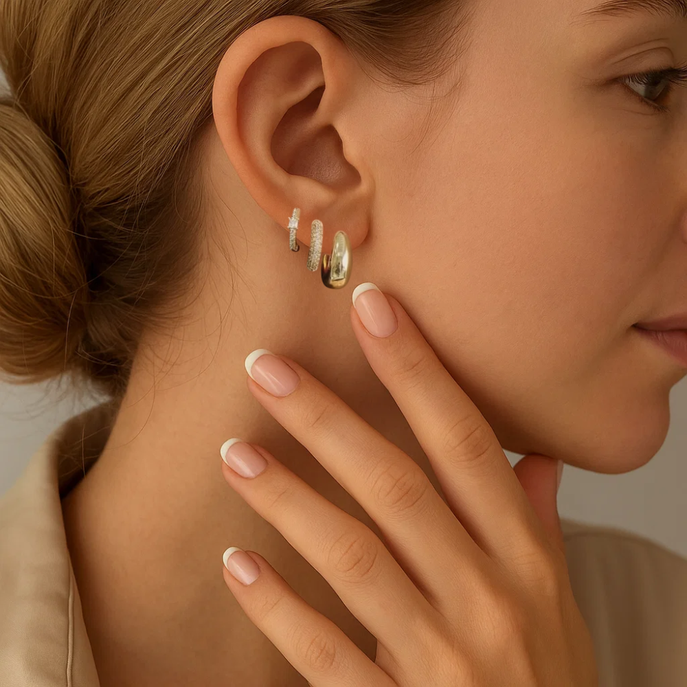 Close-up of a woman wearing hoop earrings with a neutral background