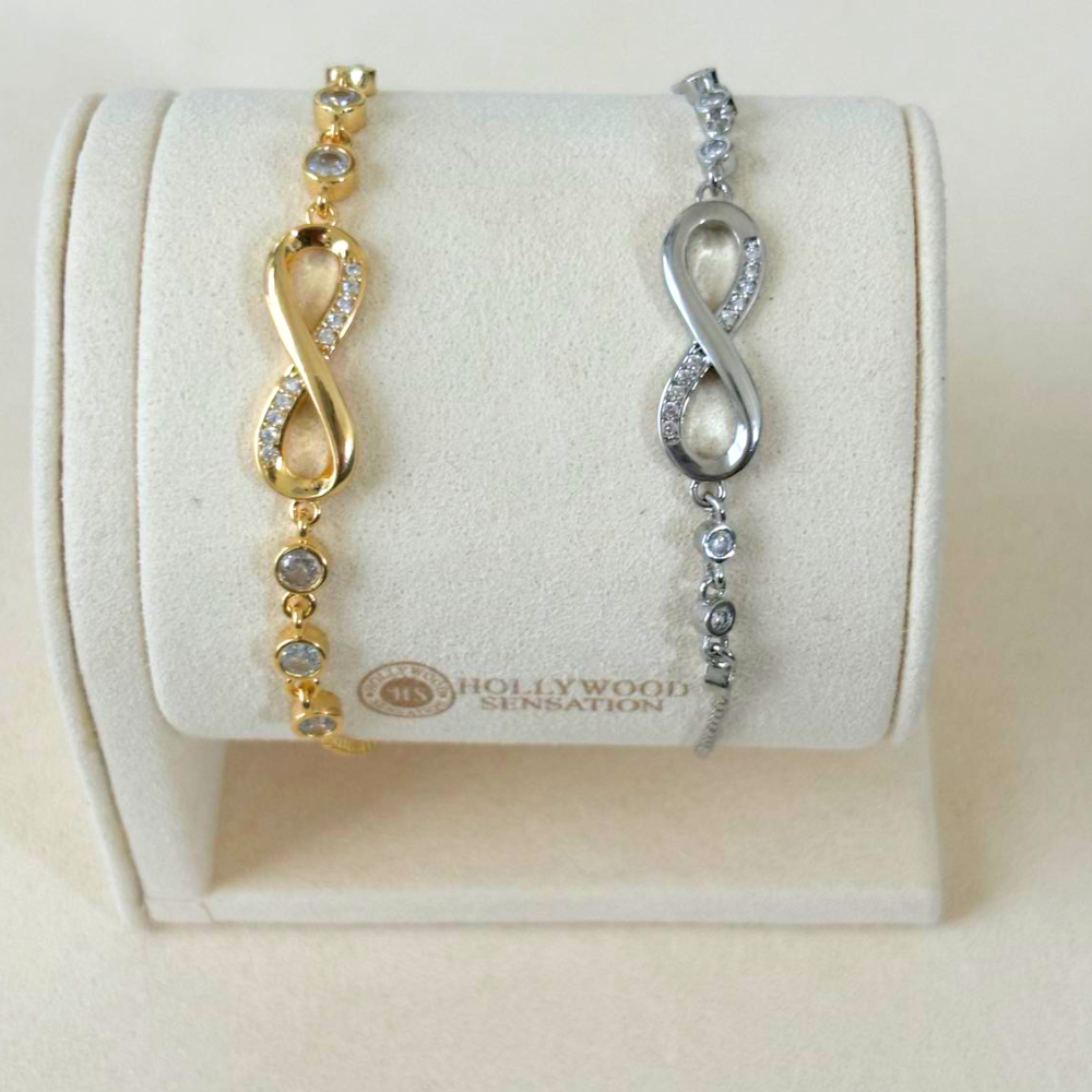 Gold and silver infinity bracelets on display, each with crystal infinity charm