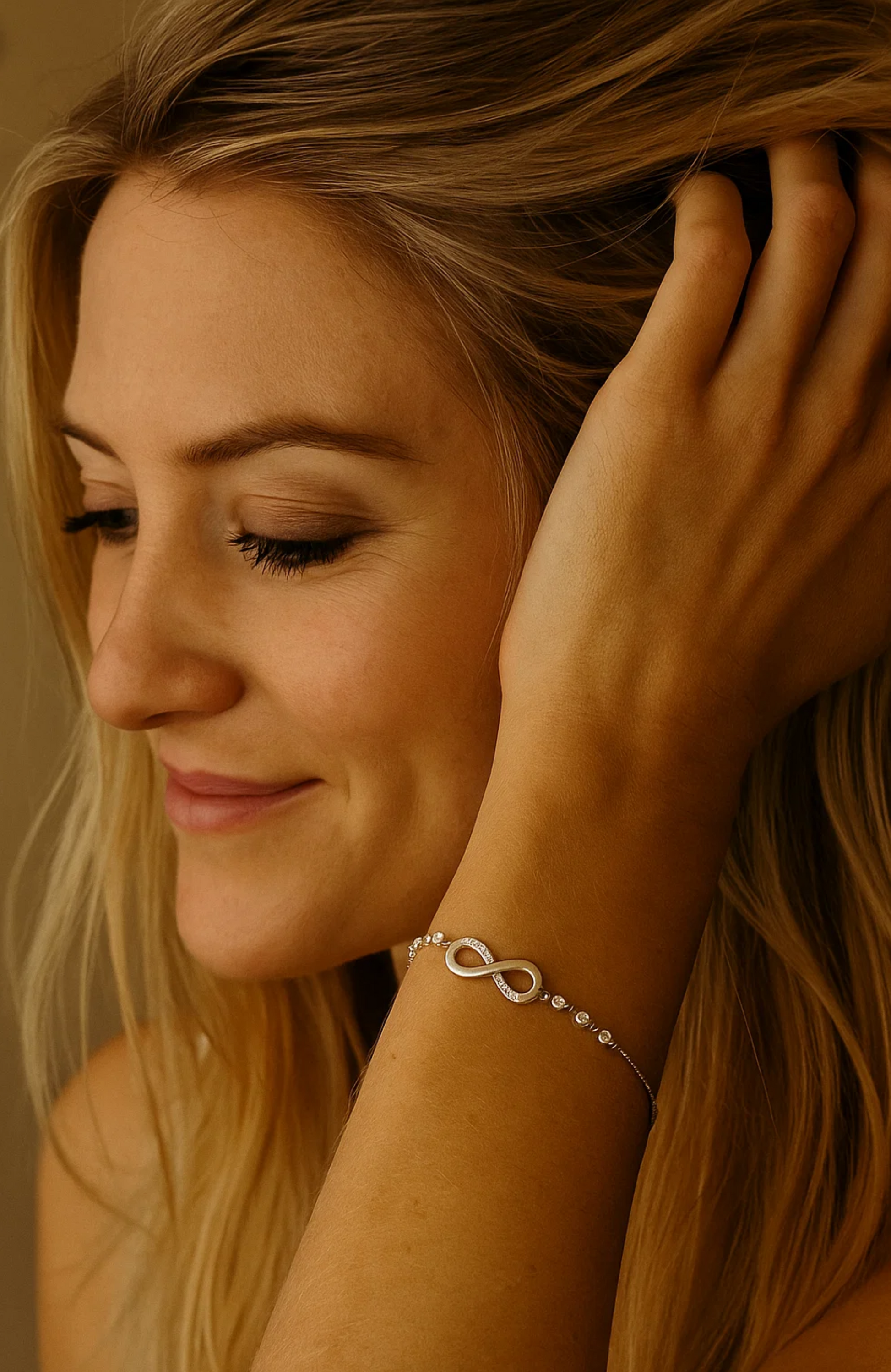 Gold-tone infinity charm bracelet with bead accents on model's wrist