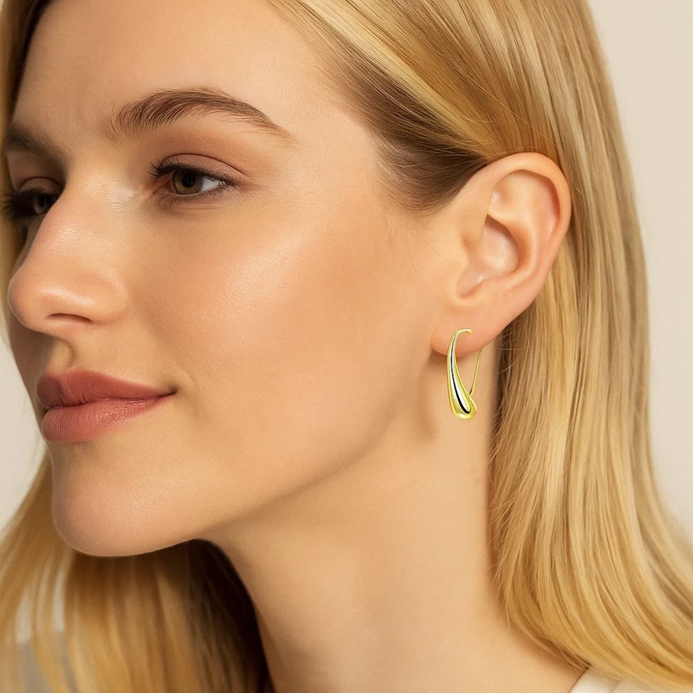 Gold teardrop dome hoop earrings on model, profile