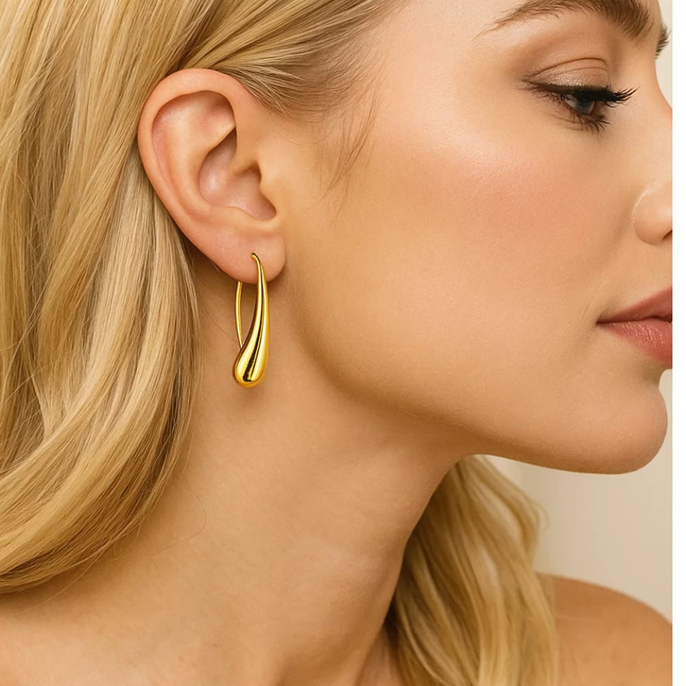 Gold teardrop dome hoop earrings on model, profile close-up