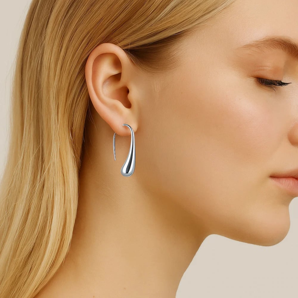 Silver teardrop dome drop hoop earrings on model, slim curved profile, polished metal