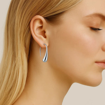 Silver teardrop dome drop hoop earrings on model, slim curved profile, polished metal