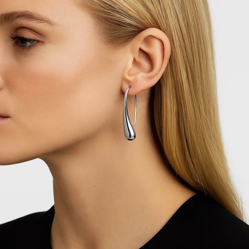 Silver teardrop dome hoop earrings on model, close side view