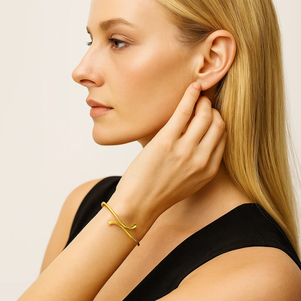 Gold teardrop open wrap bangle bracelet worn on forearm, curved teardrop charm