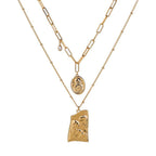 Gold layered necklace with Jesus pendant and round medallion, linked chain.