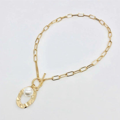 Gold link necklace with large oval pendant and white simulated pearl centerpiece