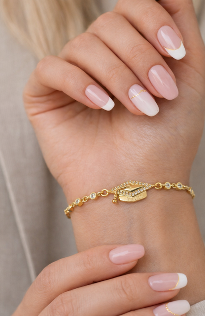 Gold pavé graduation cap bracelet on wrist