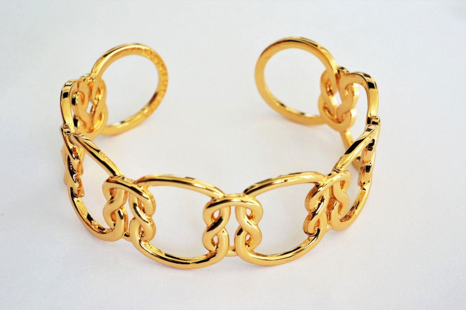 Gold love-knot link bracelet with oval links and small knot charm accents