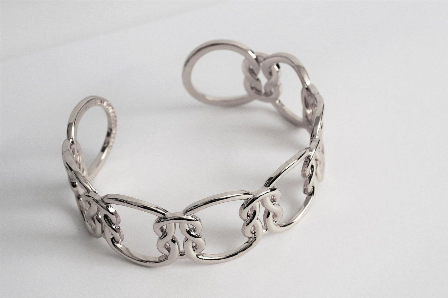 Silver chain love-knot bracelet with interlocking ring links and clasp detail