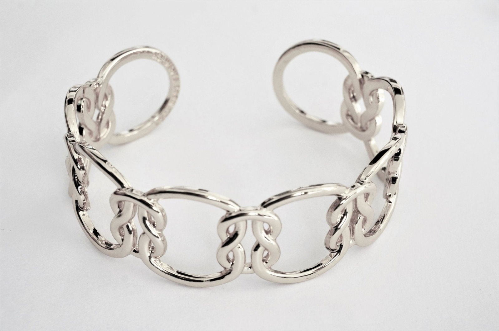 Silver love-knot link bracelet with oval links and small knot charm accents