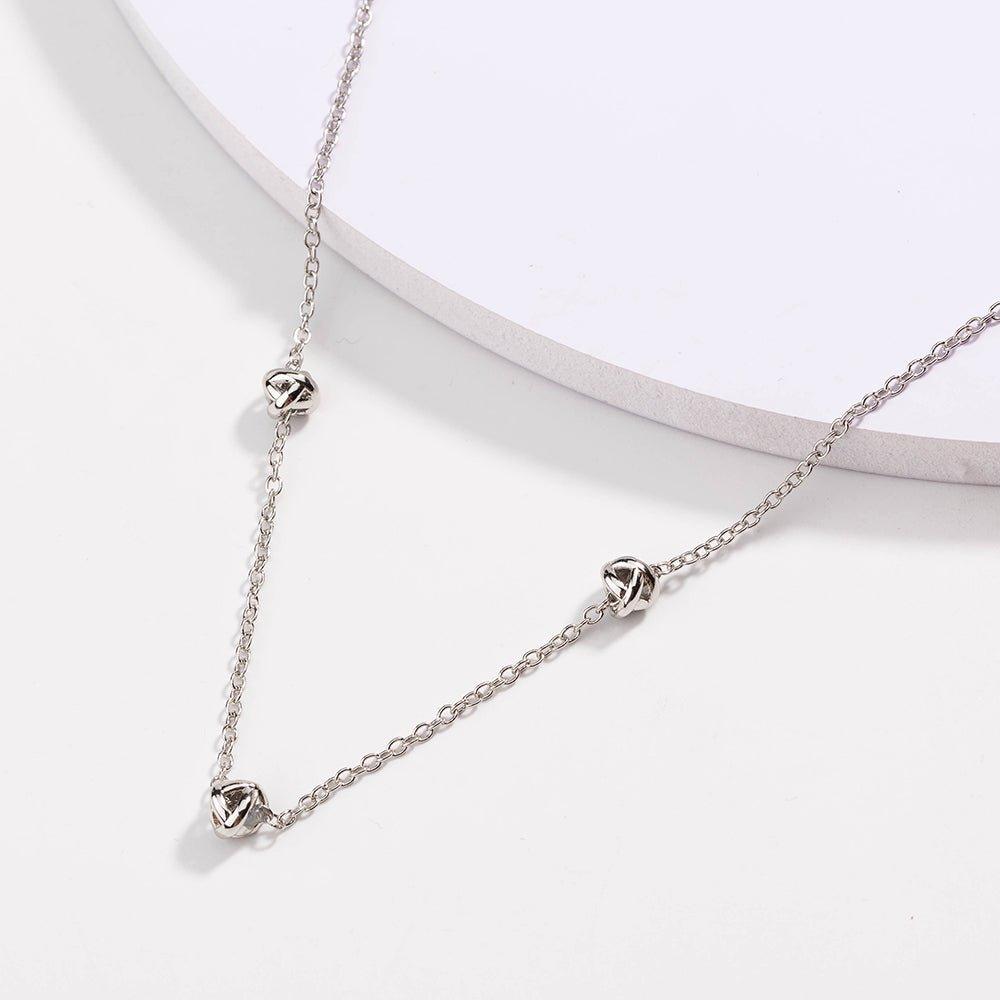 Silver-tone chain necklace with love-knot clasp and small knot pendants