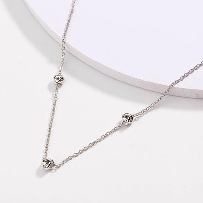 Silver-tone chain necklace with love-knot clasp and small knot pendants