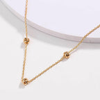 Gold-tone chain necklace with love-knot clasp and small knot pendants