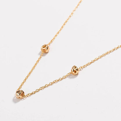 Gold-tone chain necklace with love-knot clasp and small knot links
