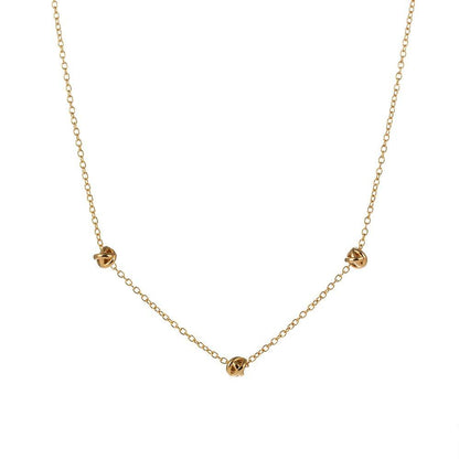 Gold-tone chain necklace with small love-knot pendant at the center