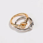Two-tone love knot commitment ring, interwoven gold and silver polished bands