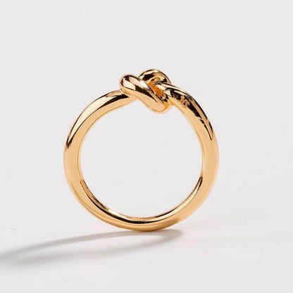 Gold love knot commitment ring with raised knot element, glossy shine