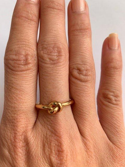 Gold love-knot commitment ring with twisted knot detail, polished band