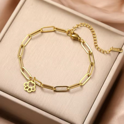 Gold paw-print link bracelet with small charm on a chain bangle
