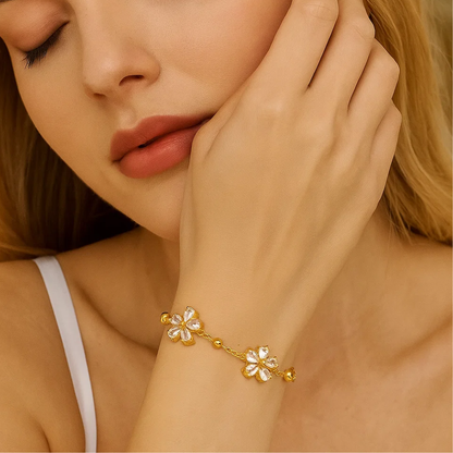 Gold-tone bracelet with crystal flower charm details and small bead accents