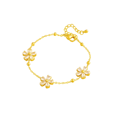 Gold-tone crystal blossom bracelet featuring three flower charms along the chain