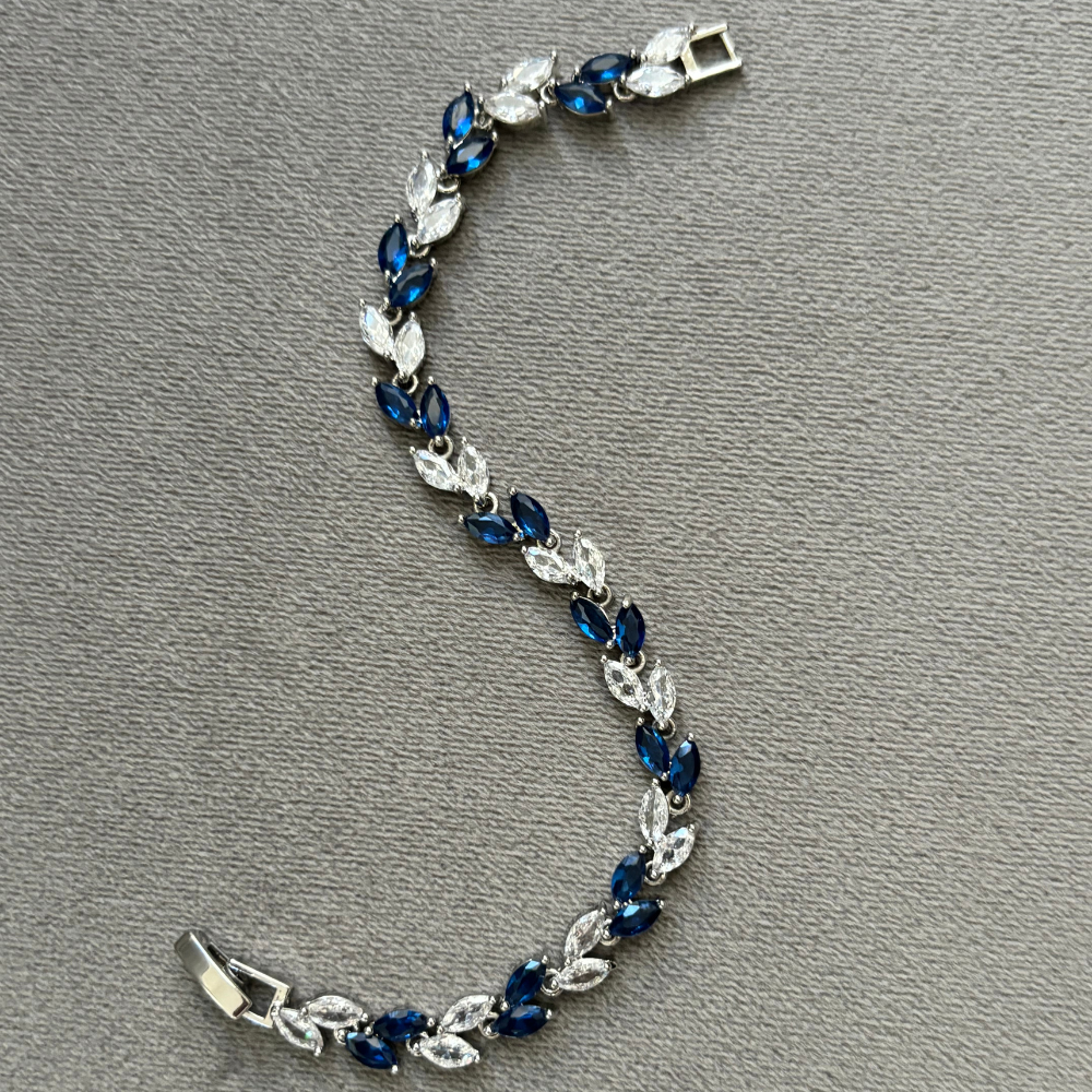 Silver tennis bracelet with blue and clear marquise stones, open box clasp, full view