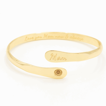 Gold-tone engraved mom cuff bracelet with script “Mom” and round emblem