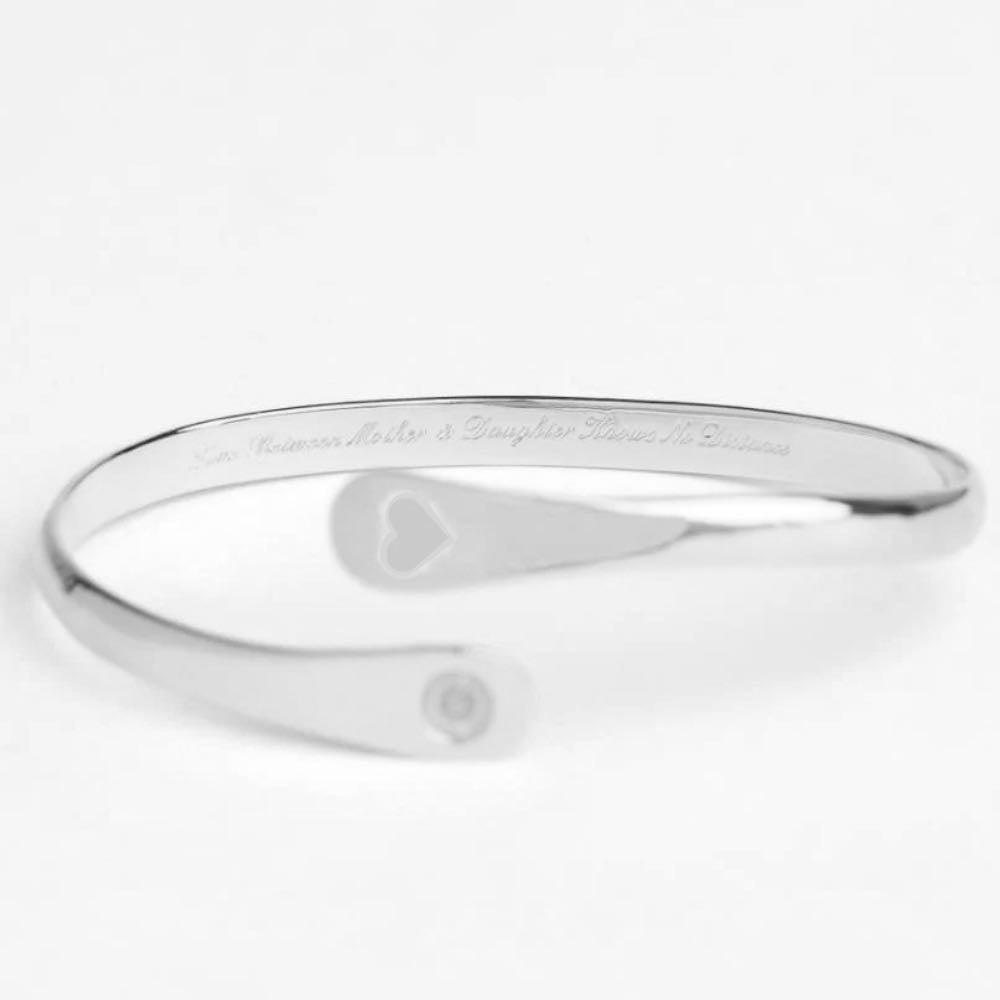 Silver engraved cuff bracelet with heart cutout and round logo detail