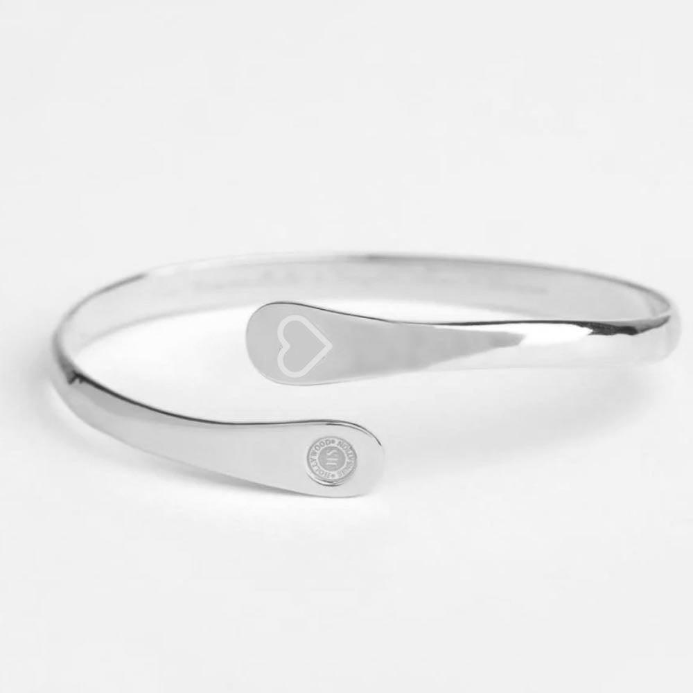 Silver cuff bracelet with engraved heart motif and round logo charm