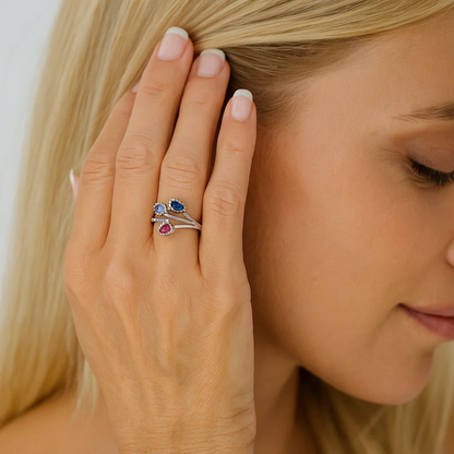 Silver-tone cubic zirconia ring with blue oval stone and red/pink drop accent