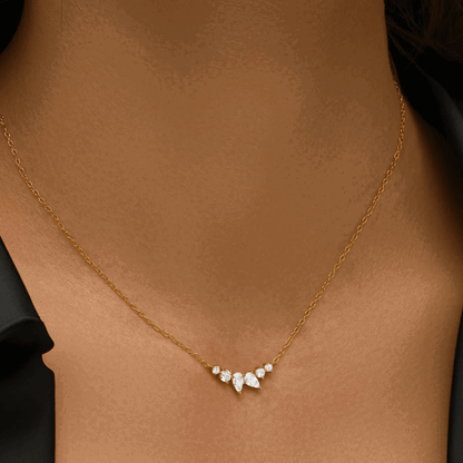 Gold-tone necklace with pear-shaped and round-cut cubic zirconia cluster, close-up