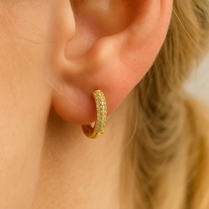 Gold pavé huggie hoop earring on ear