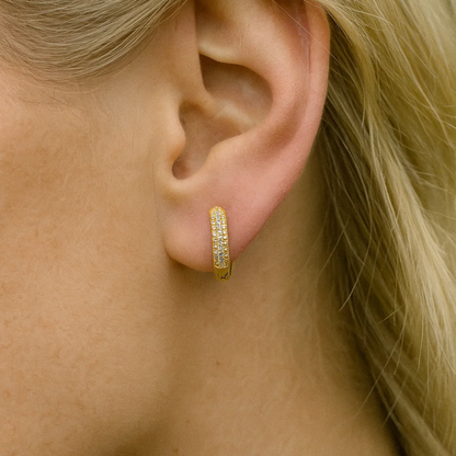 Gold pavé huggie hoop earring on ear