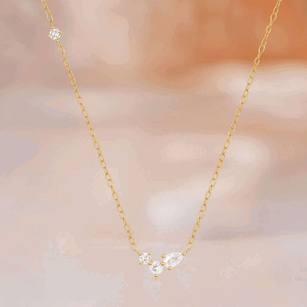 Gold-tone delicate necklace featuring three round and one pear cubic zirconia stones